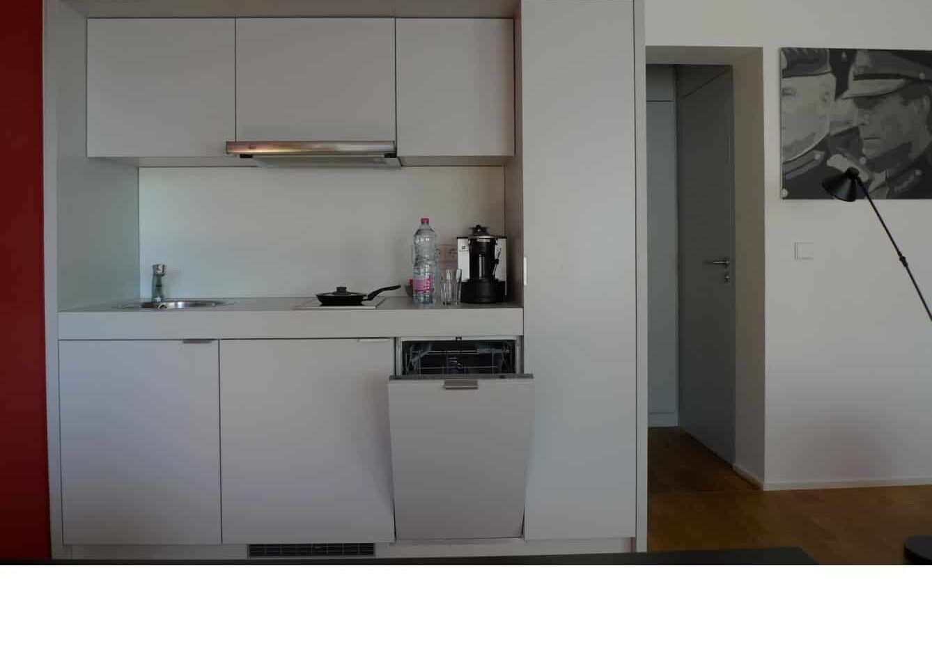 Keyinn Serviced Residences Parc de Merl kitchen with white cabinets, espresso machine & frying pan.