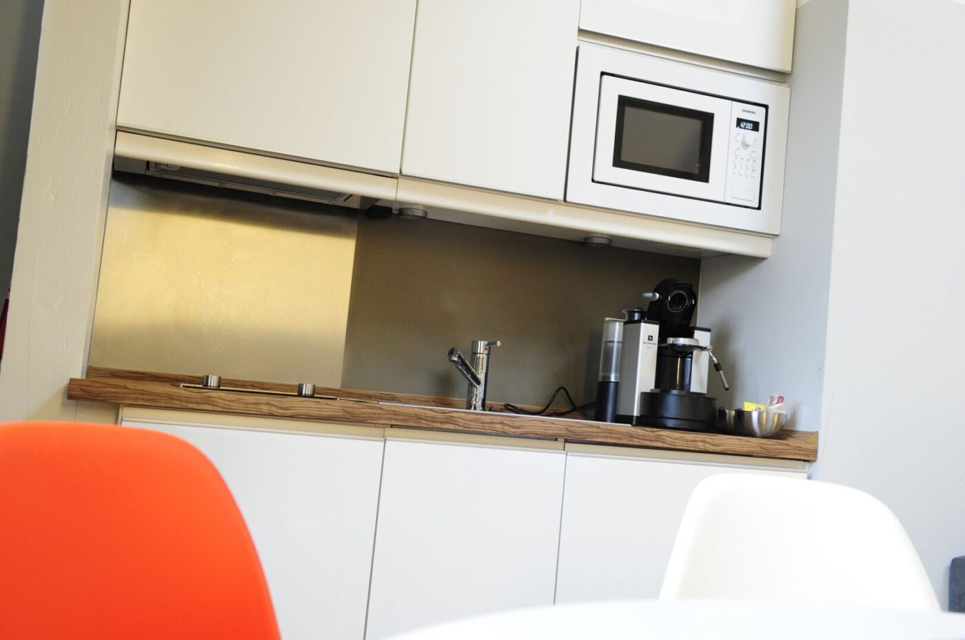 Keyinn Serviced Residences in Limpertsberg kitchenette, featuring an espresso machine, microwave, and stainless steel sink.